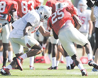 Ohio State linebacker Ryan Shazier, left, tackles running back Bri’onte Dunn at practice. There is a nagging feeling clinging to the Buckeye defenders that they somehow let everyone down last season. So this season, they
feel they owe everyone — the team, the fans, and college football in general — a little bit of payback.