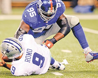New York Giants defensive tackle Rocky Bernard (95) sacks Dallas Cowboys quarterback Tony Romo (9) during the first half of an NFL football game Wednesday in East Rutherford, N.J. The Cowboys won 24-17.