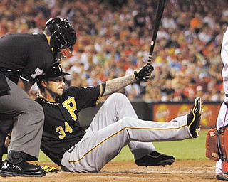 Home plate umpire Manny Gonzalez tries to help the Pirates’ A.J. Burnett up after Burnett fell to the ground after striking out with the bases loaded in the fourth inning of Wednesday’s baseball game against the Cincinnati Reds in Cincinnati. The Pirates fell to the Reds, 2-1.