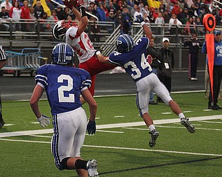 NICK MAYS l THE VINDICATOR (24) Chris Hillier of Niles goes high to snag the ball as (34) Tad Duran tries to break up the play in the first quarter of thier game in Poland. Niles vs Poland 09142012 Poland, Ohio