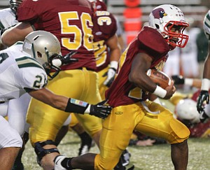 ROBERT K. YOSAY | THE VINDICATOR --..Grabbing in vain SVSM is #28 Vincent Lockett as Mooneys #10 Justus Ellis Moore breaks through the line for a first down during first half action - Akron St Vincent St Mary @ Cardinal Mooney at YSU Stadium..(AP Photo/The Vindicator, Robert K. Yosay)