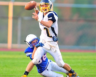 Mcdonald quarterback  #2 Christian Rusinowski tries to throw a pass while Western Reserve linebacker #86 Tim O'Connell tries to bring him down to the ground.