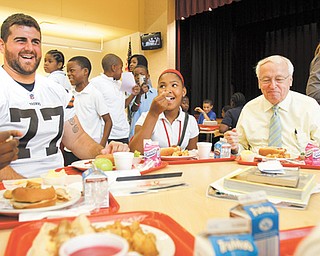 John Greco, left, a Cleveland Browns offensive lineman and Boardman native, and Kevin Concannon, the United States Department of Agriculture food and nutrition service undersecretary, eat lunch with Calayla Abron, a seventh-grader at Youngstown’s Wilson Middle School. Concannon joined Wilson students for lunch Tuesday to talk about the new guidelines for school lunches, which require healthier options.