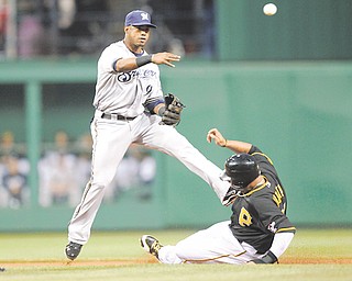 Milwaukee Brewers shortstop Jean Segura, left, throws to first after forcing out Pittsburgh Pirates’ Jose Tabata on the front end of a double play that Andrew McCutchen hit into during the first inning of a game in Pittsburgh on Tuesday.