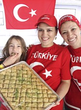 Gulay Yazar of Canfield, center, her daughter, Edanur, 9, and sister, Nurten Toslu of Philadelphia, baked the baklava and grape leaves sold at the Turkish booth at the Arab-American Festival of Youngstown Saturday.
