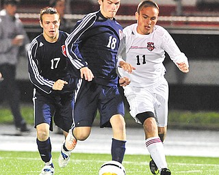 Fitch’s Kyle Kosco (18) battles with Canfield’s Mike Piersante (11) for control of the ball at midfield. Fitch’s Alex Smith (17) also is pictured.