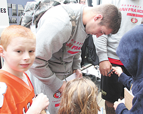 Autograph seeker Kyle DeBucci, left, of New Middletown waits his turn for an autograph from 49ers tight end Garrett Celek outside the Boardman Holiday Inn on Wednesday.
