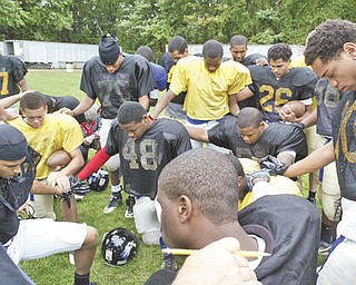 Youngstown Christian School players join in prayer before practice at Ipe Field.