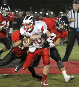 ROBERT  K.  YOSAY  | THE VINDICATOR --..Brought down after a first down during second quarter action -  is Niles #40  StefanYuhas - by Canfields #84  Kyle Nagy and #2 Nick Annichenni - after he got the first down ..Niles at Canfield - Bob Dove Field ..(AP Photo/The Vindicator, Robert K. Yosay)