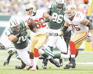 San Francisco 49ers wide receiver Mario Manningham (82) breaks a tackle by New York Jets defensive end Mike DeVito (70) during the first half of Sunday’s NFL game in East Rutherford, N.J. The 49ers routed the Jets, 34-0, with Manningham, a Warren native, recording three catches for 47 yards, plus a 28-yard gain on an end-around.