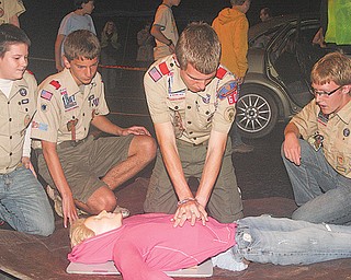 Members of Boy Scout Troop 60, from left, Nick Leonard, Nick Long and Kevin McNally observe as Quinton Currie performs CPR on a fake injured victim Tuesday. The scouts were participating in an emergency preparedness drill to learn first aid.