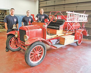Austintown firefi ghters Dave Schertzer, left, Brian Griffin and Tom Neff stand by the department’s 1917 Ford Model T firetruck. They plan to use the truck in parades and event appearances. The truck was donated to the department by Lisa Callahan and Linda Toth, whose father had owned it for 60 years.