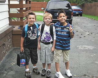 Neighbors Santino, Landon and Christian, all of Boardman, hang out together while waiting for the bus on the first day of school.