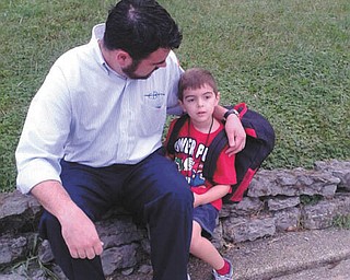 Joseph Richley of Poland offers last-minute encouragement to his son, Nathan, 5, while waiting for the school bus on the first day of kindergarten. Nathan is a student at Dobbins Elementary School in Poland.
