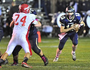 Brookfield quarterback #12 Jeremy Quinlan runs the ball on the option play while reading the action of Edgewood defensive end #24 Josh Vass.