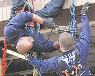 Youngstown firefighters Capt. Barry Finley, left, and Lt. Jamie Goodlet demonstrate a high-angle rescue Sunday.
