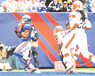 New York Giants wide receiver Victor Cruz catches a touchdown pass in front of Cleveland Browns cornerback Trevin Wade (26) in the second half of Sunday’s NFL game in East Rutherford, N.J. Cruz had a career-best three touchdown catches in the Giants’ 41-27 win over the Browns.