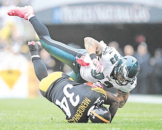 Philadelphia Eagles DE Jason Babin (93) tumbles over Pittsburgh Steelers RB Rashard Mendenhall (34)
as he tackles him after a long run in the first quarter of Sunday’s NFL game in Pittsburgh. Mendenhall, making
his return from ACL surgery, finished with 81 rushing yards and a score while adding 20 receiving yards. The
Steelers edged the Eagles, 16-14 when kicker Shaun Suisham drilled a 34-yard field goal as time expired.