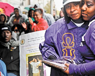 Janae Ward, of Akron, right, awards Shirlene Hill a plaque for best banner during Sunday’s Nonviolence Parade and Rally in downtown Youngstown. Hill was representing her son, Jamail Johnson, a Youngstown State University student who was killed when gunfire broke out at an off-campus party in February 2011. Hundreds
attended the march and rally in cold and rainy conditions Sunday.
