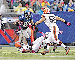 Cleveland Browns defensive back Buster Skrine (22), running back Chris Ogbonnaya (25) and linebacker L.J. Fort try to stop New York Giants wide receiver Rueben Randle (82) as he carries the ball during the first half of an NFL game Sunday in East Rutherford, N.J. The Giants won 41-27.