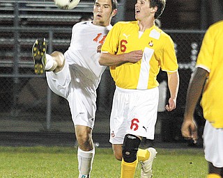 Howland’s Jacob Froats (11) and Cardinal Mooney’s Pat Price battle for the ball during Tuesday’s soccer game in
Howland. Mooney won 4-2.