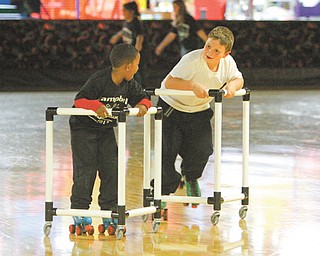 Jawaylyn Bankston, left, and Shawn Paul Joseph take it easy as novice skaters. They were at the Skate Zone in Austintown on Wednesday as a reward for passing their math and reading Ohio Achievement Assessment tests last year.