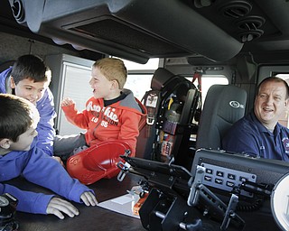MADELYN P. HASTINGS | THE VINDICATOR
(L-R) Benjamin Wilcox, 7, Josh Wilcox, 10, Eli Barr, 5, and Eric Barr all from Hubbard, Ohio sit in a fire truck at the Hubbard fire open house on October 11, 2012.