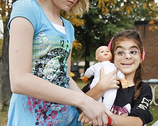MADELYN P. HASTINGS | THE VINDICATOR
Serenity Sanders, 10, places a Smile Train bracelet on Carolynn Armstrong, 8, at EJ Blott Elementary during Smile Day. Smile Train is a non-profit organization that arranges programs worldwide such as Smile Day. Smile Day was held to raise money for cleft palate surgeries of children in the area. One surgery costs $250 and the school raised $369.15 by collecting loose change from students and faculty. Carolynn recently received the surgery.