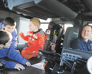 From left, Benjamin Wilcox, 7, Josh Wilcox, 10, Eli Barr, 5, and firefighter Eric Barr, all from Hubbard, enjoy the inside of a fire engine at the Eagle Joint Fire District and Hubbard Volunteer Fire Department’s open house. The truck was one of four engines that children and families could see during Thursday’s event.