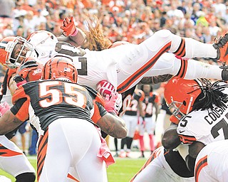 Cleveland Browns running back Montario Hardesty (20) leaps over Cincinnati defenders for a 1-yard touchdown in the fourth quarter of an NFL game Sunday at Cleveland Brown Stadium. The Browns defeated the Bengals, 34-24, to win their first game of the 2012 season and snap an 11-game losing skid.