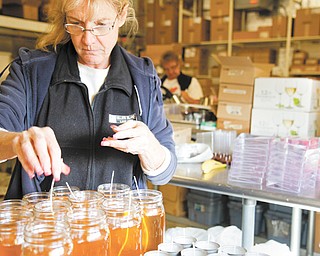 Victoria Bray places wicks in her homemade candles.