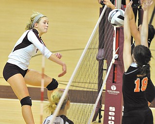 Boardman’s Megan Volosin, left, spikes the ball as Howland’s Olivia Goodman (18) tries to make a block at the net Tuesday night. The Spartans swept the Tigers in three games in a first-round sectional match at tow-Munroe Falls High School.