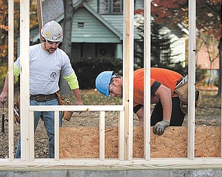 Work is under way on the new American Legion Post 472 on East Indianola Avenue on Youngstown’s South Side. Members of Core 6+, a group of eight people, most of whom are business owners, dedicated to community-service projects that bring the community together and help those in need, are involved in the project. Working on the framing Wednesday were Justin Rance, left, of Salem and Joe Csizmadir of Vienna.