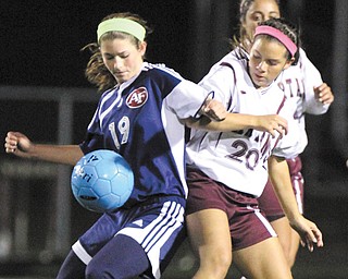 Fitch’s Lauren Bower (19) tries to keep the ball from Boardman’s Breana Crenshaw (20) during the Division I sectional final Thursday in Boardman. Alison Green powered the Spartans to a 5-1 victory over the Falcons with three consecutive goals.