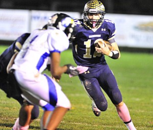 Brookfield quarterback #12 Jeremy Quinlan scrambles with the football.