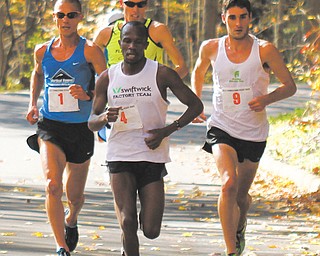 Julius Bor of Erie, Pa., (4) leads a group of runner through Mill Creek Park during the middle leg of the 10K race during the 38th annual Peace Race on Sunday. Bor broke out early and held off Aiman Scullian of Kent to win with a time of 29:54.2.