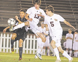 Jonah Wilson (13) and Andrew O’Leary (5) of South Range battle Garfield’s Ante Dejanovic (14) for control of the ball in the first half of a Division III district semifinal Tuesday night. Garfield won, 1-0, and will meet Crestview in a district final Saturday.