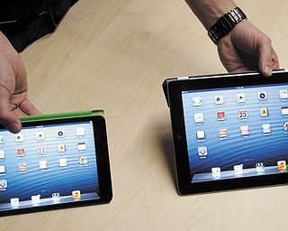 The iPad Mini, at left, is shown next to the 4th Generation iPad in San Jose, Calif. On Tuesday, Apple Inc. revealed the iPad Mini, with a screen that’s about two-thirds the size of the full-size model, and said it will cost $329 and up.