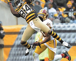 Steelers wide receiver Antonio Brown (84) catches the ball in front of Redskins defensive back Cedric Griffin (20) during the second quarter of Sunday’s NFL game in Pittsburgh. Pittsburgh, sporting throwback jerseys from the 1930s, won downed Washington, 27-12.