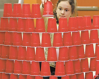 Addison Fonderlin, a second-grader at Hilltop Elementary in Canfield, works on building the tallest plastic-cup tower. Addison and her class participated Thursday in STEM Week at the school for the second year in a row, which consists of science, technology, engineering and math experiments for students to test.