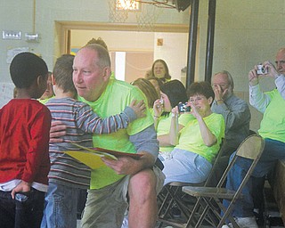 Bill Sheldon, an Austintown schools custodian for 18 years, hugs Lynn Kirk Elementary students who created songs, books and poems for him. Sheldon, who was diagnosed with lymphoma in August, is undergoing chemotherapy and will start working at Fitch High because of a lowered immune system.