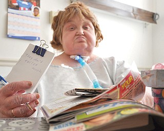MaryAnn Steerman holds a note expressing her frustration at the news that Valley Renaissance Healthcare
Center is discharging her and 13 others because the respiratory-care unit is being closed, a move that is
happening more often because of Medicaid and Medicare reimbursement cuts.