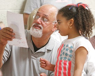 Ralph Santos, a veteran who served four years in the Navy aboard the carrier JFK, reads a thank-you note from Victoria King, a second-grader at Stadium Drive Elementary School in Boardman. More than 100 veterans attended the event Thursday.