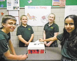 Holy Family School, Poland, conducted a mock presidential debate and election. The tradition began in 1988. Students in third through eighth grades were eligible to vote. Shown are Michael Puhalla, grade 7, casting his vote; Kieran Burke, grade 8; Ellie McDanel, grade 8; and Michelle Hanna, grade 7, placing her ballot in the box. When the votes were counted, Mitt Romney received 62 percent of the votes while Barack Obama received 38 percent.