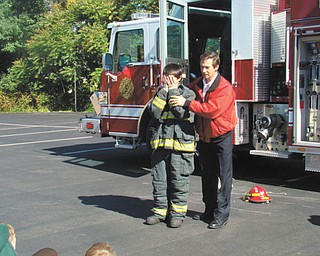 Members of the Eagle Joint Fire District of Hubbard visited St. Patrick School in Hubbard, where firefighters explained the importance of fire safety and demonstrated what to do in case of a fire at home or at school. Students toured the fire trucks and had the opportunity to spray water from a fire hose. Seventh-grader Julian Maiorano dressed in the turn-out gear that a firefighter would wear to a fire call. He is shown with Captain John Petro, Hubbard Fire Department.