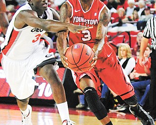 Youngstown State guard Kendrick Perry (3) drives to the basket against Georgia’s John Florveus (32) during Monday’s NCAA basketball game in Athens, Ga. The Penguins downed the Bulldogs, 68-56, behind Perry who posted 23 points and six rebounds.