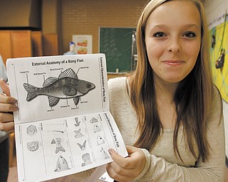 Maddi Graham, an eighth-grader at Akiva Academy in Youngstown, shows a project book she and her classmates used during a visit last month to the Stone Laboratory, The Ohio State University’s island campus on Lake Erie.