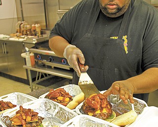 Cook Steve Jackson serves up Smokehouse burgers at Guy’s BBQ in Youngstown.