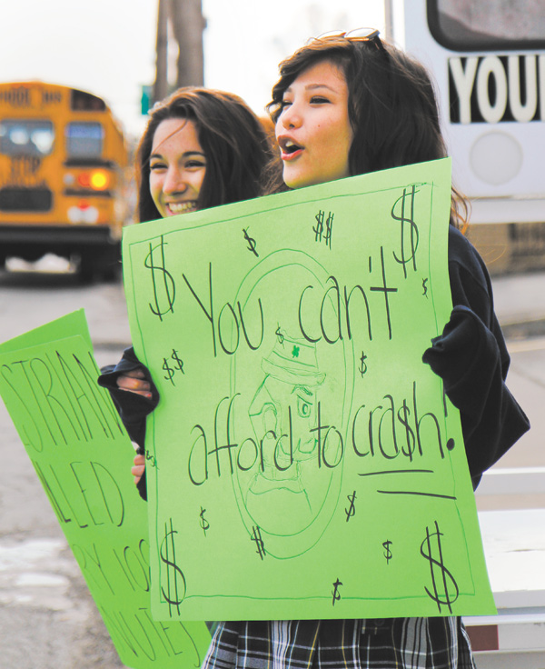 Ursuline High School sophomores Alexa Mollica, left, and Alyssa Lytle warn Wick Avenue drivers about the importance of yielding to pedestrians.