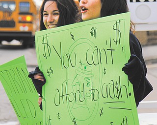 Ursuline High School sophomores Alexa Mollica, left, and Alyssa Lytle warn Wick Avenue drivers about the importance of yielding to pedestrians.